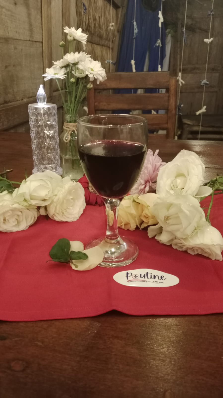 Wine, roses, candlelight, and table flowers at Poutine Gili Air